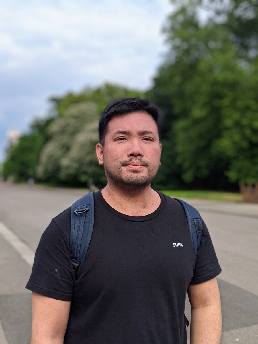 Isaac Tan in a London park, wearing a SUPA tee.